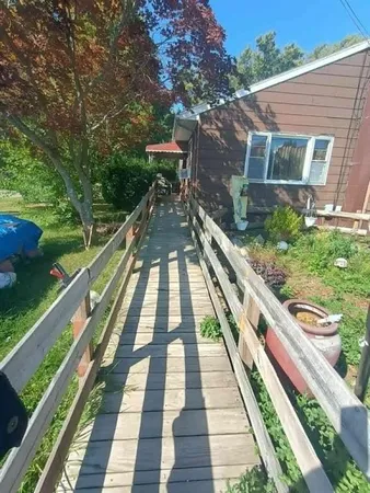 a view of a balcony with wooden floor and bench