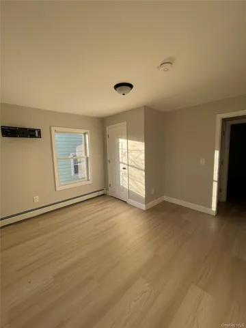 an empty room with windows and cabinet