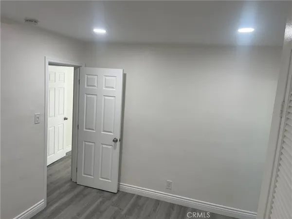 an empty room with wooden floor and closet