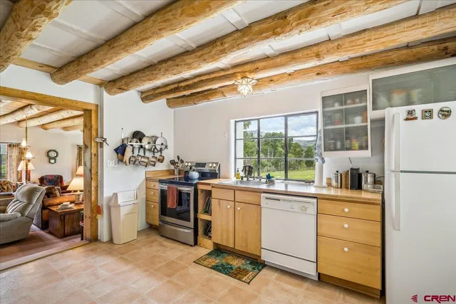 a kitchen that has a lot of cabinets in it and wooden floors