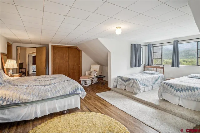 a spacious bedroom with a bed a table and large mirror