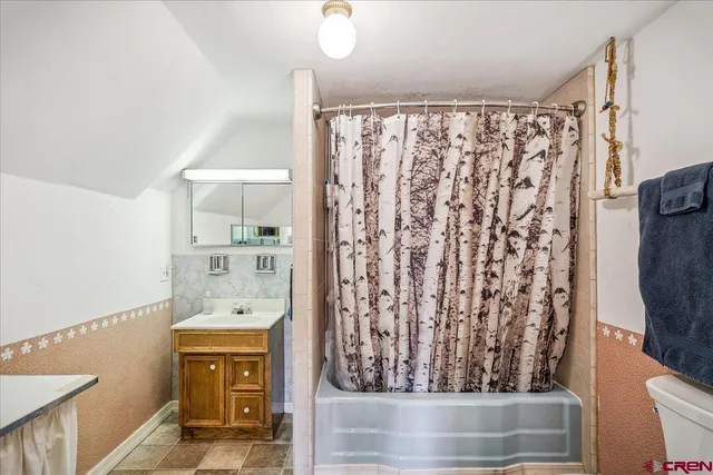 a bathroom with a sink a mirror and shower curtain