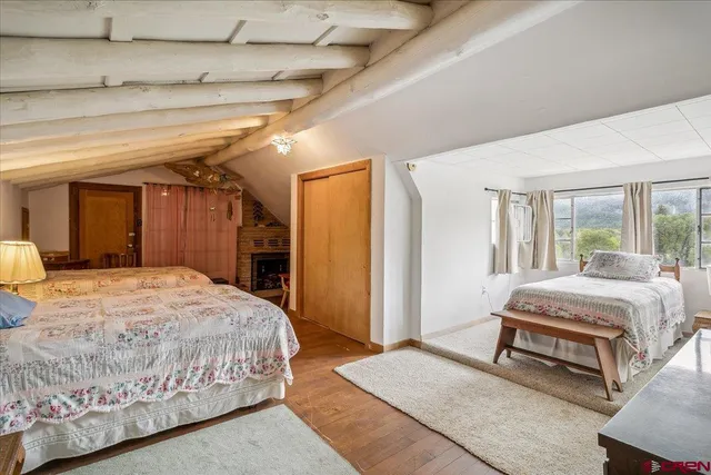 a living room with a bed and a dresser next to a window