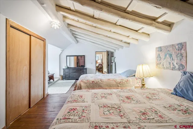 a view of a bedroom with furniture and wooden floor