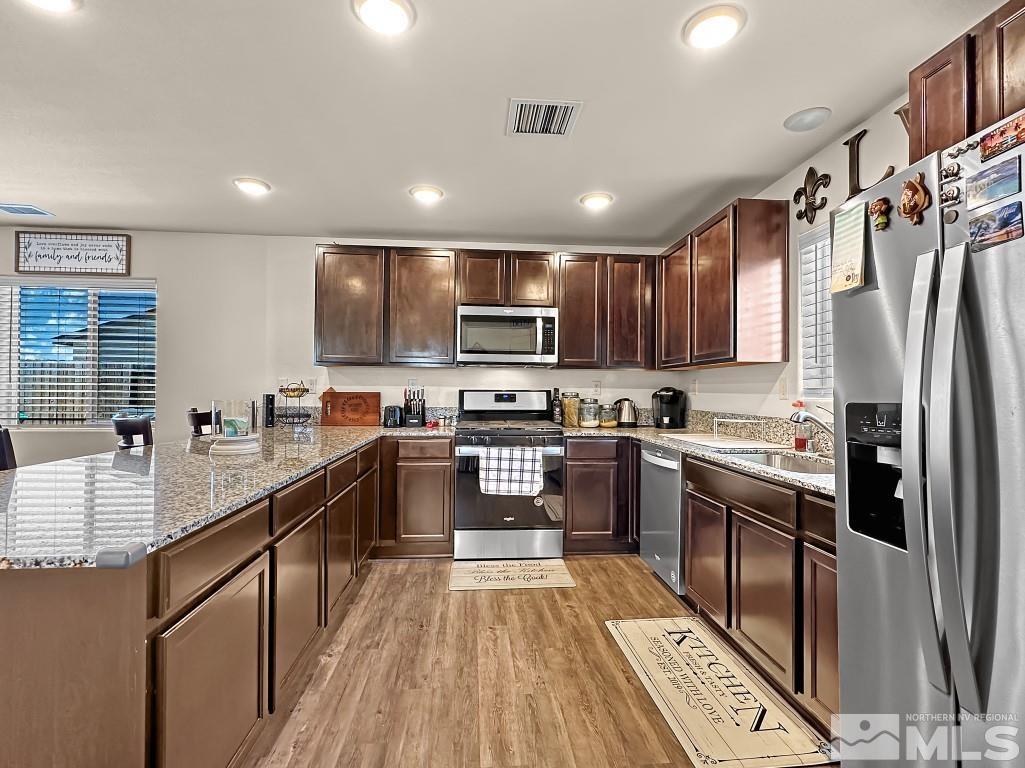 343 Double Spring Drive Reno, NV 89506 - Photo 11 of 27 a kitchen with stainless steel appliances granite countertop refrigerator a sink dishwasher a oven with wooden cabinets and a stove