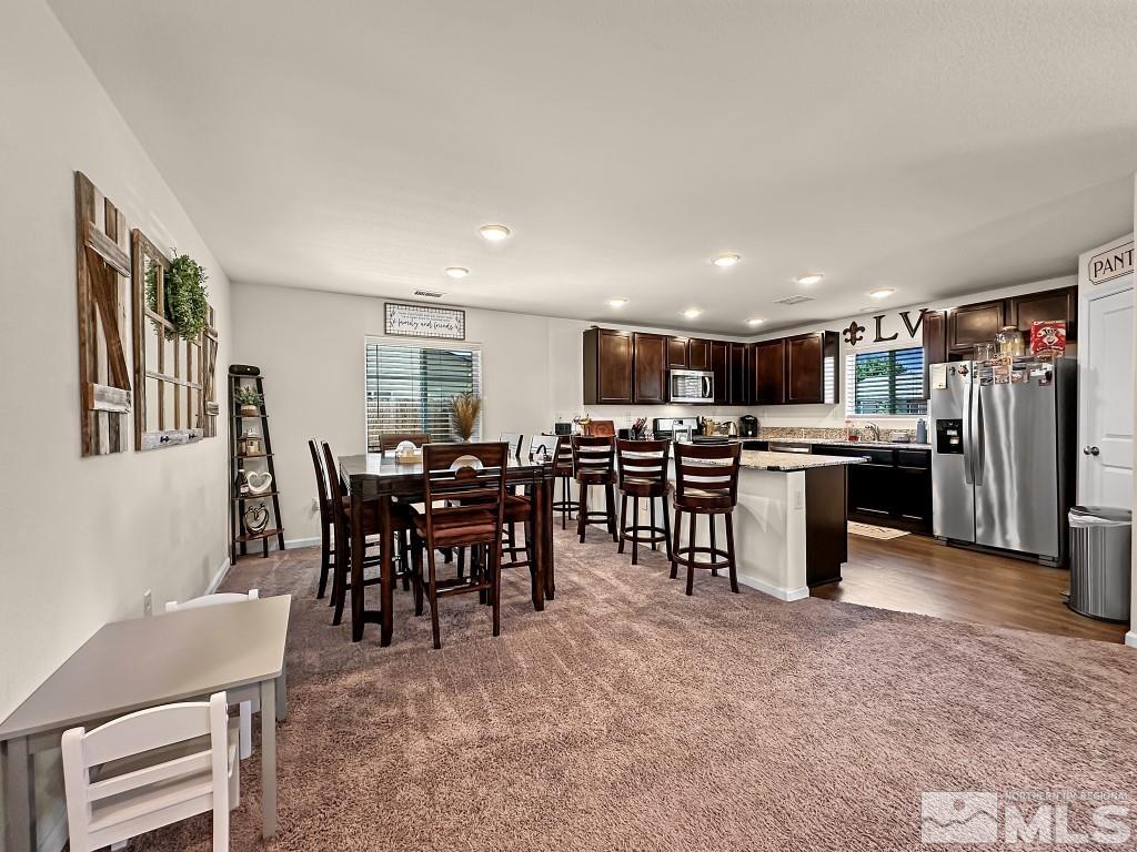 343 Double Spring Drive Reno, NV 89506 - Photo 9 of 27 a living room with stainless steel appliances kitchen island granite countertop a table and chairs in it