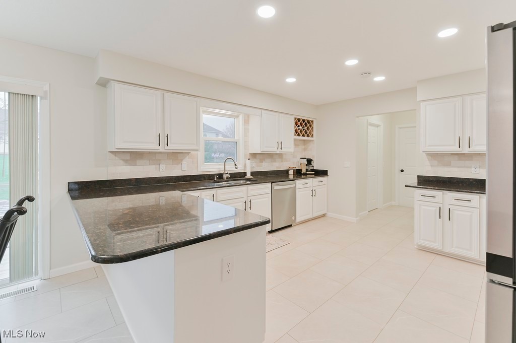 482 Longspur Road Highland Heights, OH 44143 - Photo 13 of 47 Kitchen featuring white cabinetry, a peninsula, a sink, and dishwasher