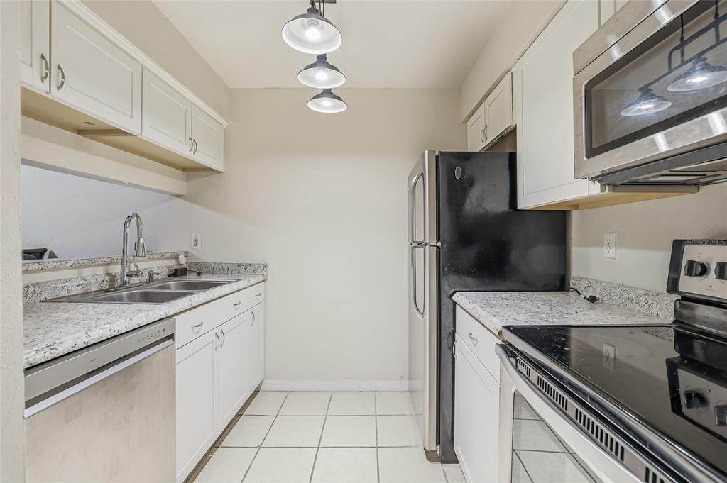 4004 Nestle Oaks Place, Unit 203 Tampa, FL 33613 - Photo 2 of 32 a kitchen with a sink cabinets and stainless steel appliances