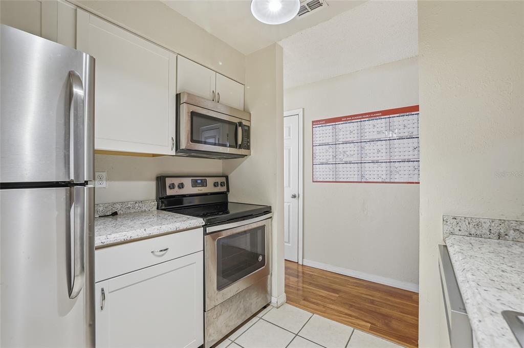 4004 Nestle Oaks Place, Unit 203 Tampa, FL 33613 - Photo 25 of 32 a kitchen with stainless steel appliances granite countertop a refrigerator and a stove top oven