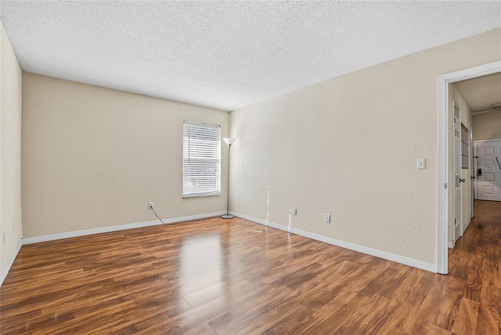 4004 Nestle Oaks Place, Unit 203 Tampa, FL 33613 - Photo 8 of 32 a view of an empty room with wooden floor and a window