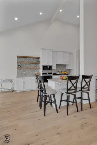 a kitchen with stainless steel appliances kitchen island granite countertop a table and chairs in it