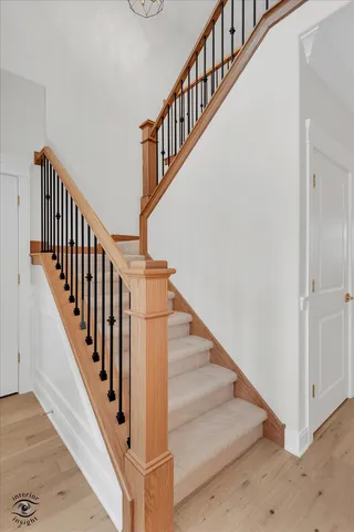 a view of staircase with railing and white walls
