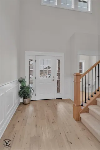 a view of a hallway with wooden floor and a potted plant
