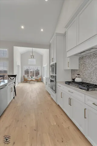 a large kitchen with stainless steel appliances a sink a stove and cabinets