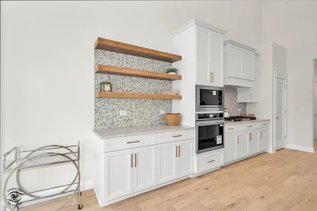 a kitchen with white cabinets and appliances