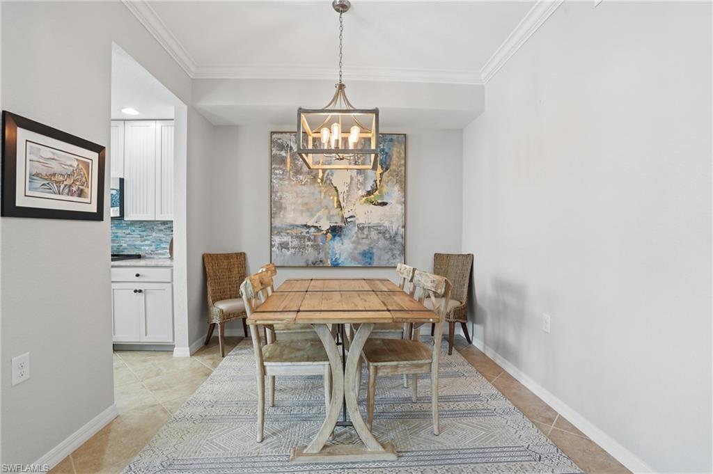 9715 Acqua Court, Unit 113 Naples, FL 34113 - Photo 12 of 31 Dining space with crown molding, hanging lights, and light tile patterned floors