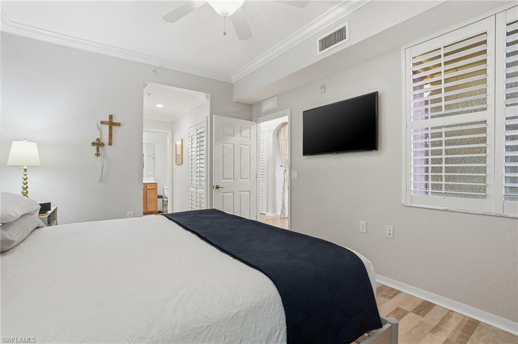 9715 Acqua Court, Unit 113 Naples, FL 34113 - Photo 14 of 31 Bedroom with light wood-style floors, crown molding, a ceiling fan, and connected bathroom