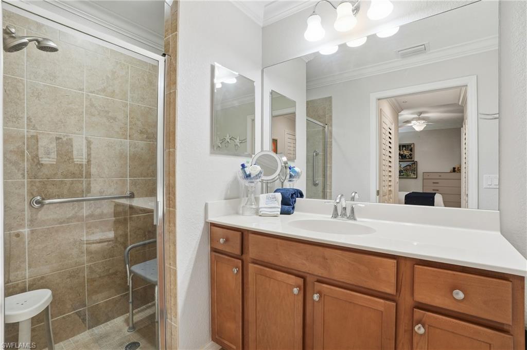 9715 Acqua Court, Unit 113 Naples, FL 34113 - Photo 16 of 31 Bathroom with a stall shower, vanity, crown molding, ensuite bath, and ceiling fan
