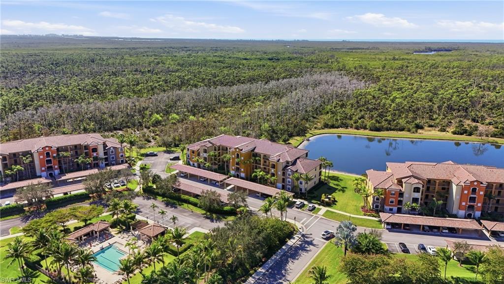 9715 Acqua Court, Unit 113 Naples, FL 34113 - Photo 25 of 31 Drone / aerial view of a forest and a large body of water