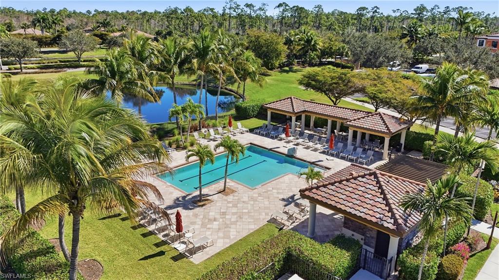 9715 Acqua Court, Unit 113 Naples, FL 34113 - Photo 28 of 31 Community pool with a patio, view of scattered trees, a water view, and a lawn