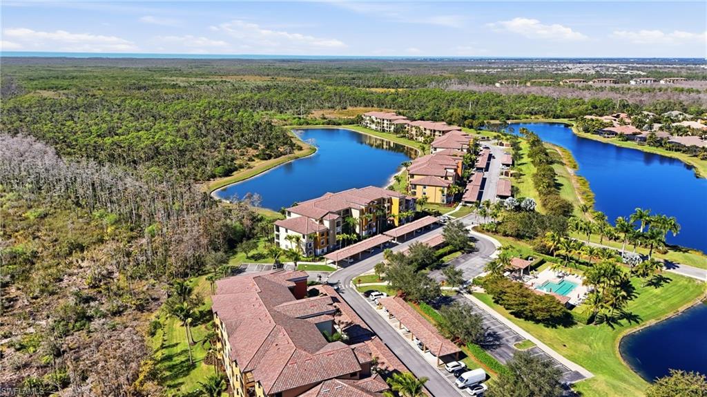 9715 Acqua Court, Unit 113 Naples, FL 34113 - Photo 29 of 31 Aerial perspective of suburban area with a large body of water and a forest