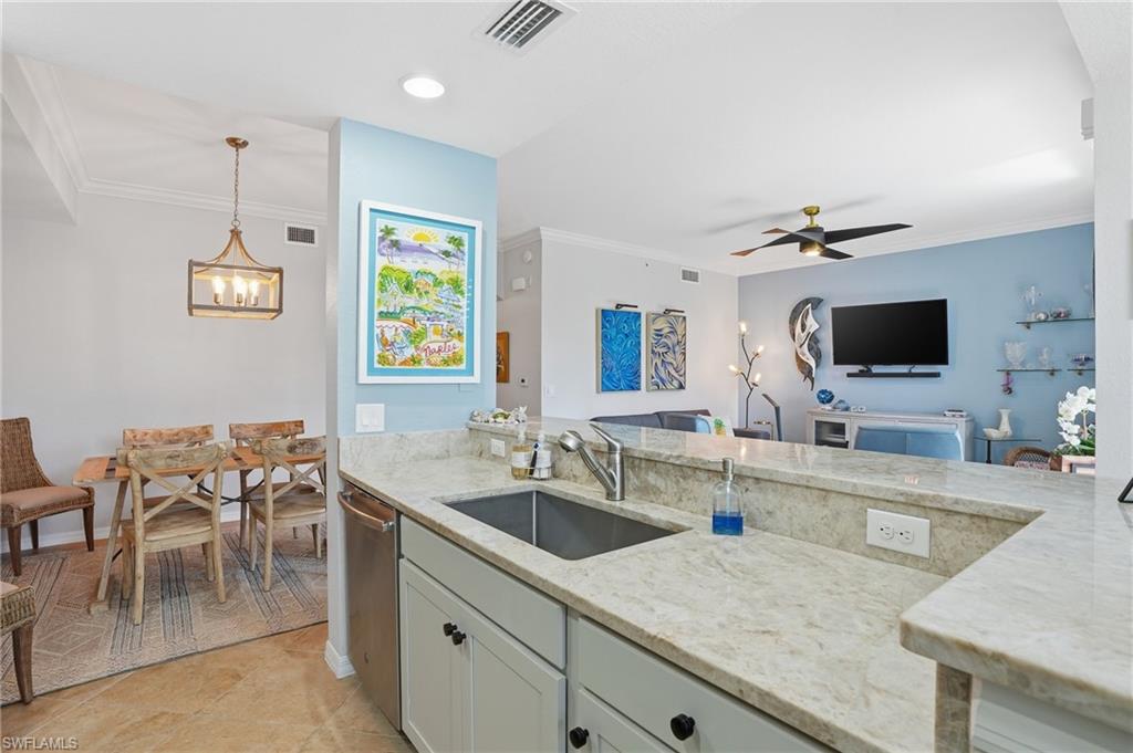 9715 Acqua Court, Unit 113 Naples, FL 34113 - Photo 6 of 31 Kitchen featuring pendant lighting, light stone counters, crown molding, ceiling fan, and stainless steel dishwasher