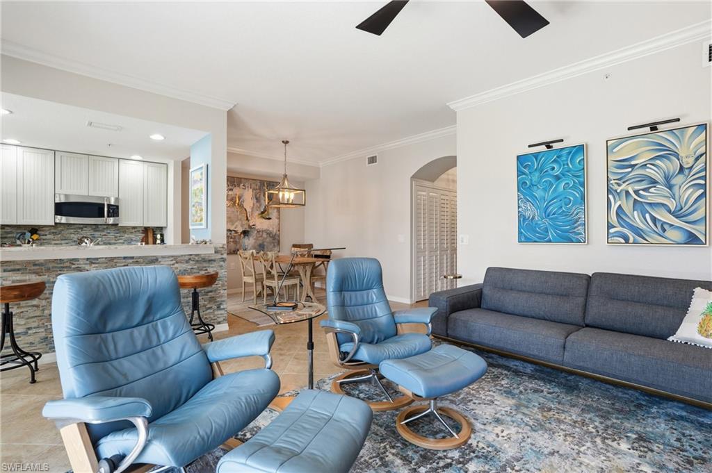 9715 Acqua Court, Unit 113 Naples, FL 34113 - Photo 9 of 31 Tiled living room with crown molding, arched walkways, and ceiling fan