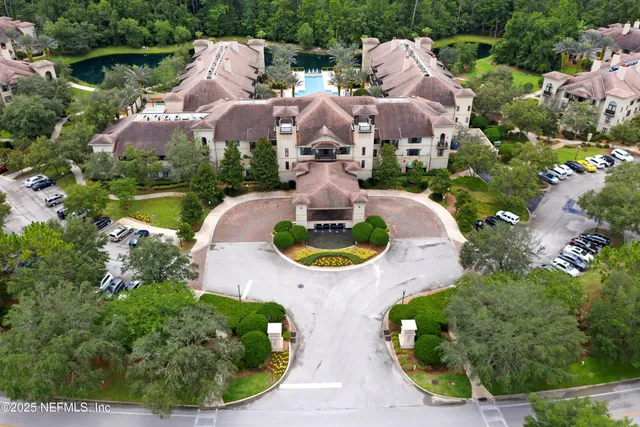 a view of a white building with swimming pool in front of it