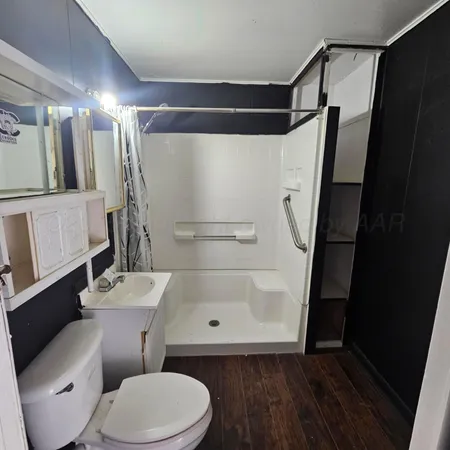 a white toilet sitting next to a shower