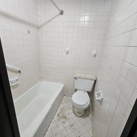 a white toilet sitting next to a bath tub and a shower
