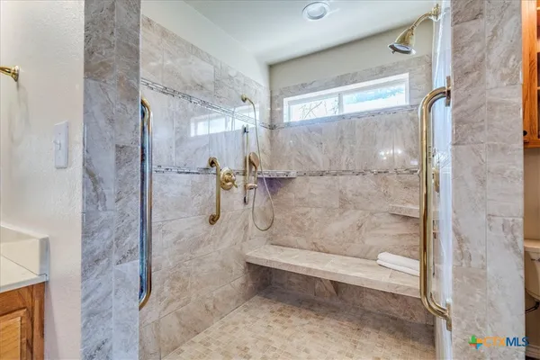 a bathroom with a granite countertop shower and a toilet