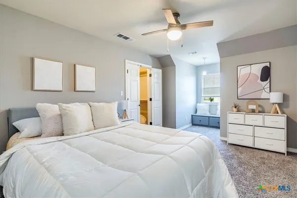 a bedroom with a large bed and a chandelier
