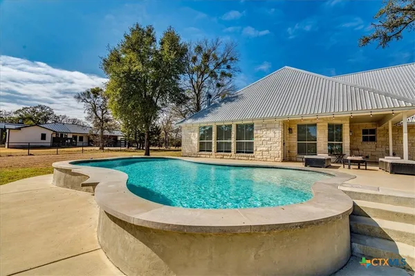 a view of a house with swimming pool and sitting area