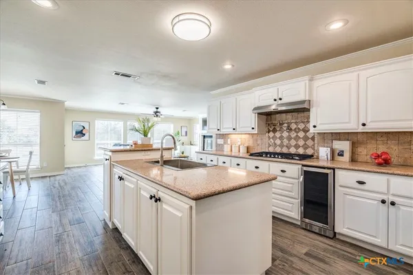 a kitchen with white cabinets appliances and center island