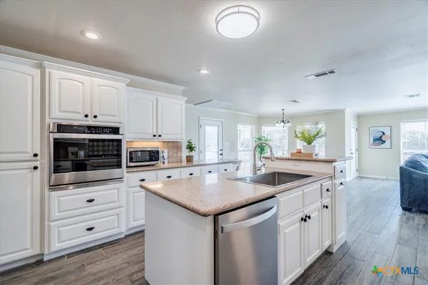 a kitchen that has a sink and a stove in it