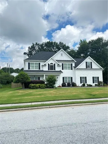 a front view of a house with a yard and trees