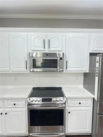 a stove top oven sitting inside of a kitchen