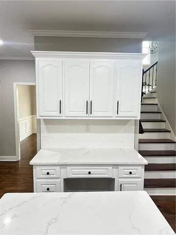 a kitchen with white cabinets and sink