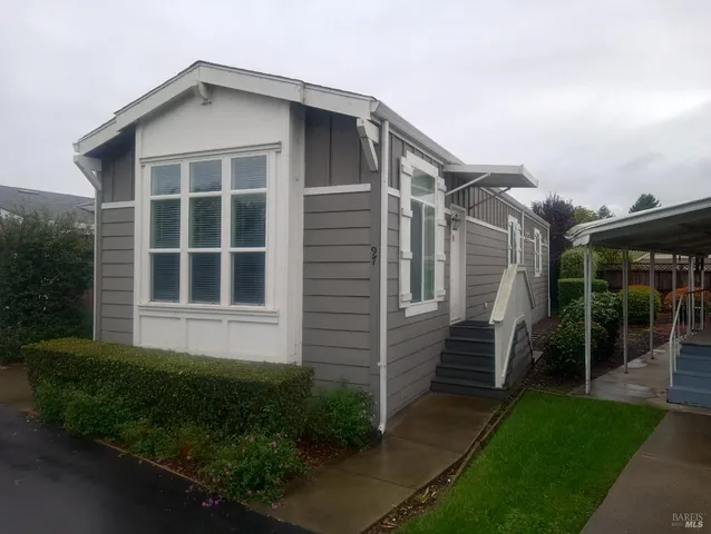 a kitchen with stainless steel appliances granite countertop a sink a refrigerator and a white cabinets