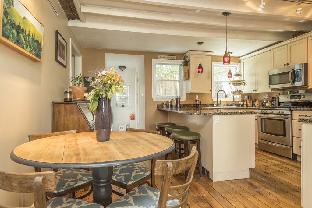 a kitchen with stainless steel appliances a dining table chairs and granite counter tops