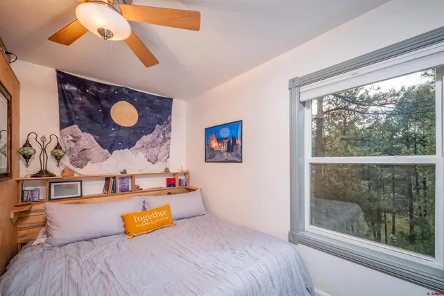 a bedroom with a bed and a painting on the wall