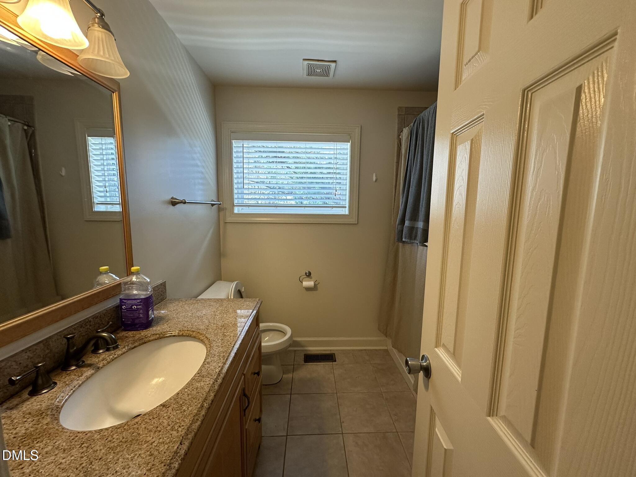 7208 Eastover Drive Raleigh, NC 27603 - Photo 16 of 41 a bathroom with a granite countertop sink and a mirror