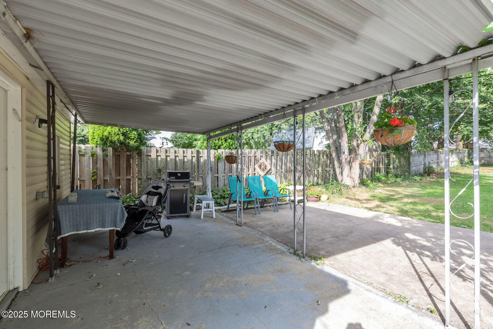301 Norwood Avenue, Unit 3 Long Branch, NJ 07740 - Photo 12 of 17 a view of a patio with table and chairs and floor to ceiling window with wooden fence