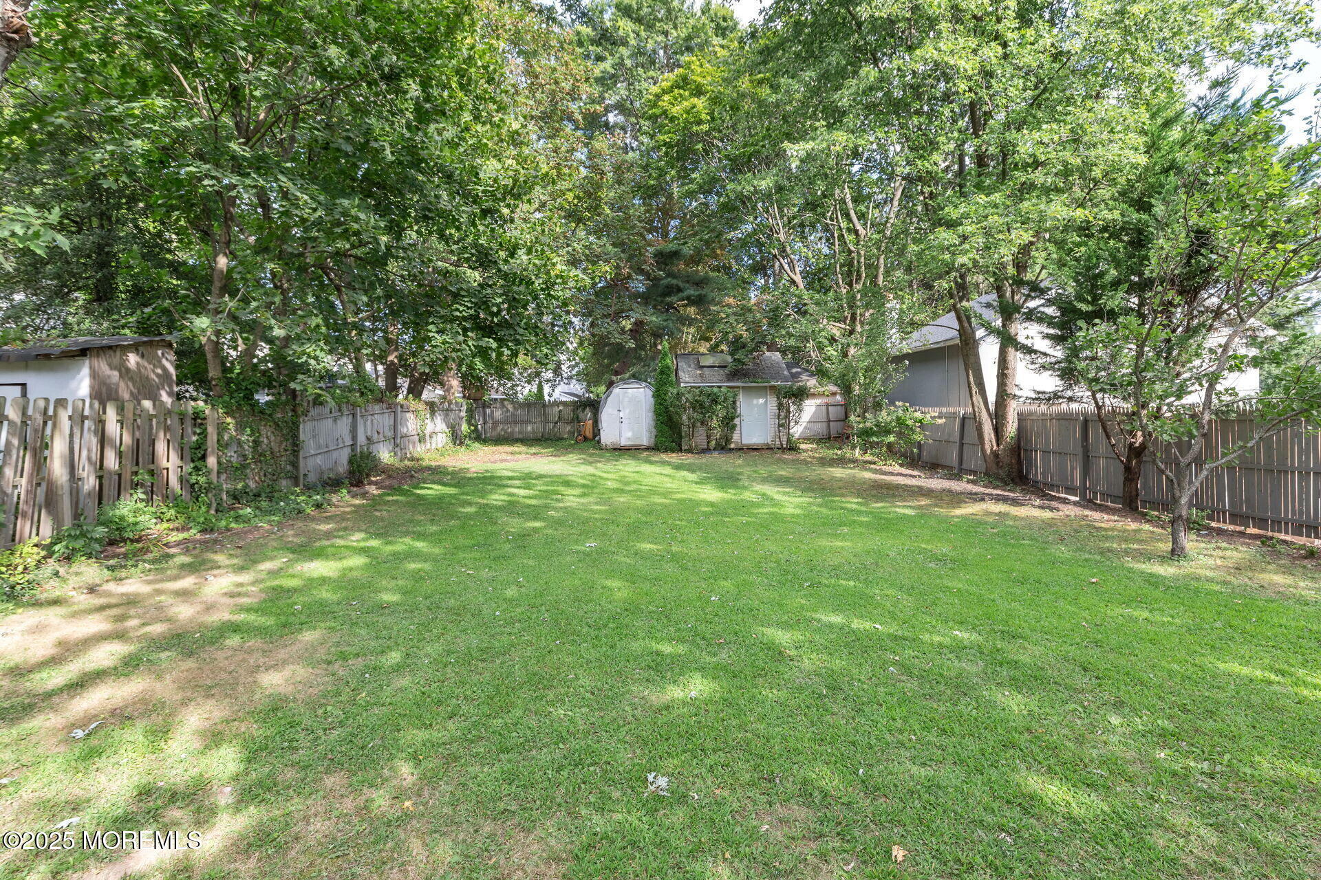 301 Norwood Avenue, Unit 3 Long Branch, NJ 07740 - Photo 15 of 17 a view of a backyard with large trees and wooden fence