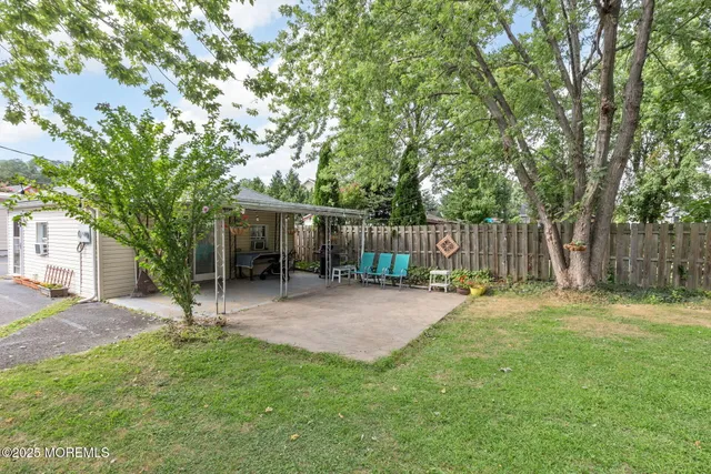 a backyard of a house with table and chairs