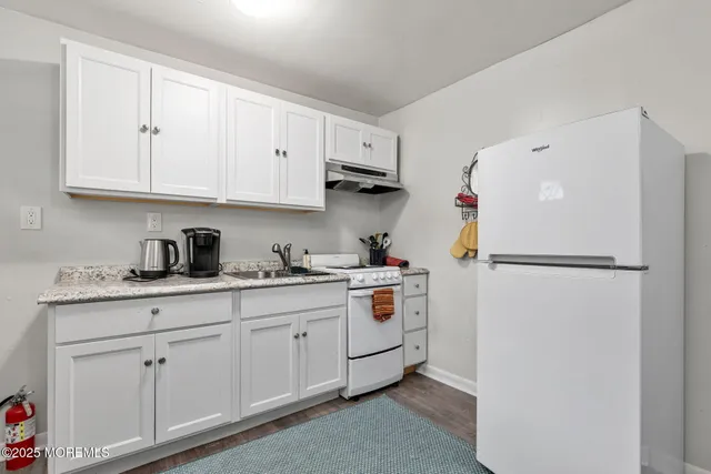 a kitchen with white cabinets and refrigerator