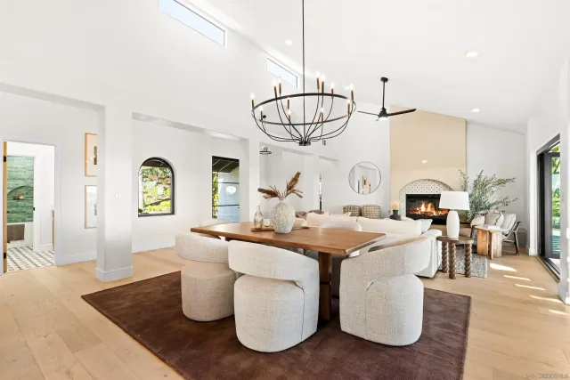a dining room with furniture a chandelier and wooden floor