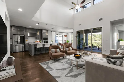 a living room with furniture kitchen view and a large window