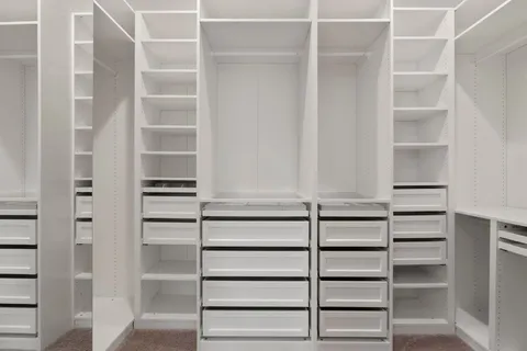 a view of walk in closet with empty racks