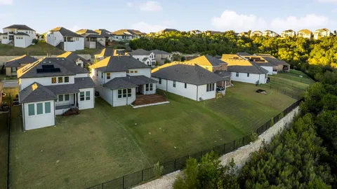 an aerial view of residential houses with outdoor space and parking